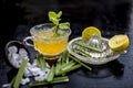 Close up of Iced lemon grass tea in a transparent cup on wooden surface with raw lemon grass green tea in a cup and sugar in a cla