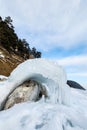 Close-up of the icy seashore. Transparent ice and icicles on the rocks on the shore. Royalty Free Stock Photo