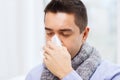 Close up of ill man with flu blowing nose at home Royalty Free Stock Photo