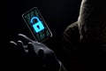 Close up illuminate unlock icon with green binary code on screen of smartphone floating above of hacker`s hand in black glove on