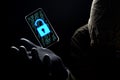 Close up illuminate unlock icon with green binary code on screen of smartphone floating above of hacker`s hand in black glove on Royalty Free Stock Photo