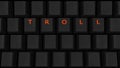 Close Up of Illuminated Glowing Keys on a Black Keyboard Spelling Troll