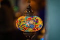 Close up of illuminated multi coloured mosaic patterned glass lamp shade