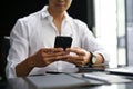 Close-up image of an Asian businessman sending sms to someone on his phone Royalty Free Stock Photo