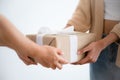 Close up image of Asian woman hands holding a gift wrapped with white ribbon