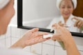 Close-up image, Attractive mature Asian lady applying makeup remover on a cotton pad