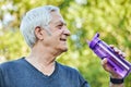 Close up image attractive mature man holds plastic reusable bottle