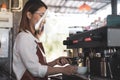 Close up image of barista wearing faceshield preparing coffee