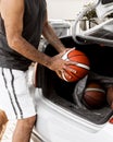 Close-up image of basketball coach puts the balls in the trunk of his car going to workout