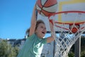 Close up image of basketball excited kid player dunking the ball, outdoor on playground. Child scoring slam dunk, stock Royalty Free Stock Photo