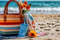 Woman's beach purse with flowers on sandy towel by sea Royalty Free Stock Photo