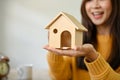 Close-up image, A beautiful Asian female putting a house model on her hands. Real estate agent Royalty Free Stock Photo