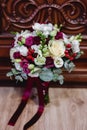 Close-up image of a beautiful , stylish wedding bouquet of red, pink roses and eucalyptus greenery on wooden background. Royalty Free Stock Photo