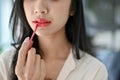 Close-up image, Beautiful young Asian woman applying red lipstick, putting on her makeup Royalty Free Stock Photo
