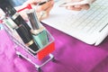 Close up image of beauty items, cosmetics in shopping cart, Woman using smartphone and credit card, Shopping online concept Royalty Free Stock Photo