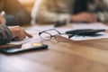 Black eyeglasses on notebook with blur businessman in office