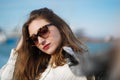 Close up image of brunette woman wearing stylish sunglasses posing outdoors. Long-haired Girl with bright makeup Royalty Free Stock Photo