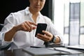 Close-up image of a businessman checking messages on hias smartphone at his desk Royalty Free Stock Photo