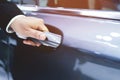 Close up image of a businessman hand on handle opening a car door. Service executive professional Pull the door to you.