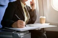 Close-up image of a businesswoman reviewing business reports while boarding a plane