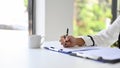 Close-up image of a businesswoman writing or signing her signature on a business document Royalty Free Stock Photo