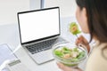 Close-up image of a busy Asian businesswoman eating healthy salad bowl, having lunch at her desk Royalty Free Stock Photo