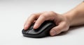 Close up image capturing a hand operating a modern black computer mouse on a white surface Royalty Free Stock Photo
