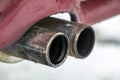 Close up image of a car dual exhaust pipe. Emission of poisonous carbon monoxide gas in atmosphere, environment pollution concept.