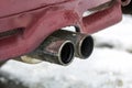Close up image of a car dual exhaust pipe. Emission of poisonous carbon monoxide gas in atmosphere, environment pollution concept. Royalty Free Stock Photo