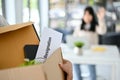 Close-up image of a cardboard box with a resignation letter and personal stuff Royalty Free Stock Photo