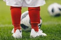 Close-up image of child soccer player with ball on grass training field