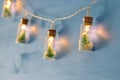 close up image of Christmas tree in the masson jar garland light over wooden blue background. Royalty Free Stock Photo