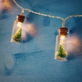 close up image of Christmas tree in the masson jar garland light over wooden blue background. Royalty Free Stock Photo