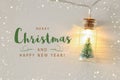 close up image of Christmas tree in the masson jar garland light over wooden white background. Royalty Free Stock Photo