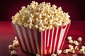 Red and White Striped Popcorn Box Filled with Buttery Popcorn, Isolated on Red Background