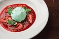 Close-up image of delicious and juicy mint ice cream scoop in plate on table with supplemented mint leaves and pieces of Royalty Free Stock Photo