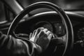 A close-up image of a driver\'s hand firmly gripping the steering wheel as their car overtakes, with a blurred background, Royalty Free Stock Photo