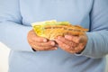 A close-up image of an elderly persons hands holding a stack of Euro banknotes Royalty Free Stock Photo