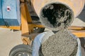 Concrete mixer pouring wet cement into wheelbarrow Royalty Free Stock Photo