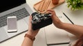 Close-up image, Female hands holding a retro camera over office desk Royalty Free Stock Photo