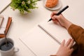 Female student doing her homework, writing on spiral school notebook