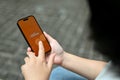 Close-up image of a female using Payoneer application while relaxing outdoors