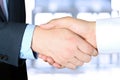 Close-up image of a firm handshake between two colleagues outsi