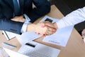 Close-up image of a firm handshake between two colleagues after signing a contract