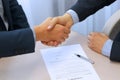 Close-up image of a firm handshake between two colleagues after signing a contract