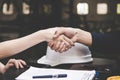 Close-up image of a firm handshake between two colleagues after signing a contract.