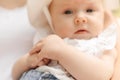Close-up image focuses on baby hands of 4-6-month-old girl in white lace dress in hands of parent. Royalty Free Stock Photo