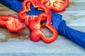 On a wooden Board is a red bell pepper, cut into slices and a ceramic black knife Royalty Free Stock Photo