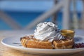 Close-up image of freshly made waffles with whipped cream