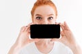 Close up image of Ginger woman showing blank smartphone screen